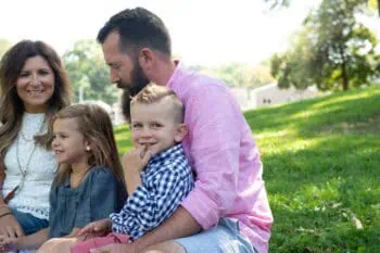 How to know if your relationship will last: a smiling couple sitting on the grass with their two young children