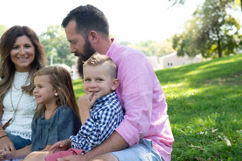 How to know if your relationship will last: a smiling couple sitting on the grass with their two young children