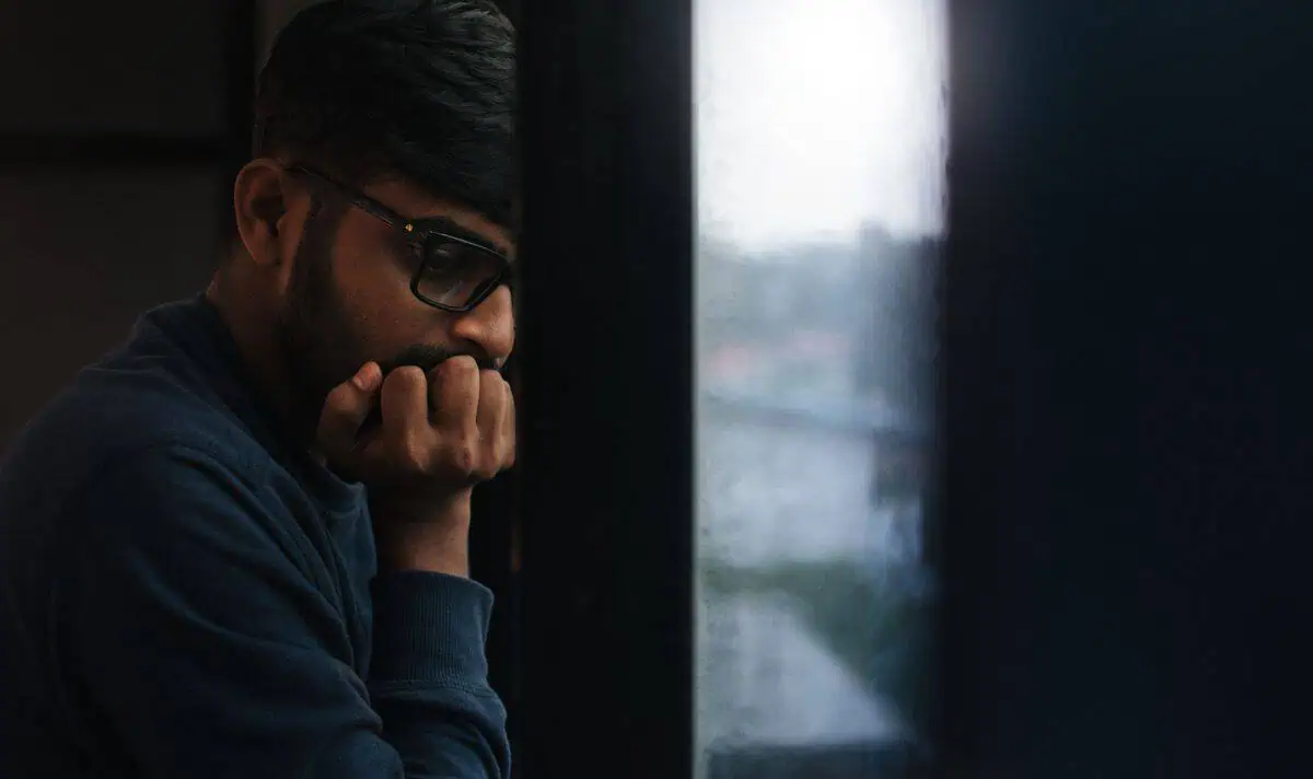 Heated Rivalry Isn't Just a Gay Hockey Love Story. It's a Mental Health Story for All of Us. 1 Heated Rivalry mental health: a contemplative man alone at a rainy window, reflecting the cost of masking