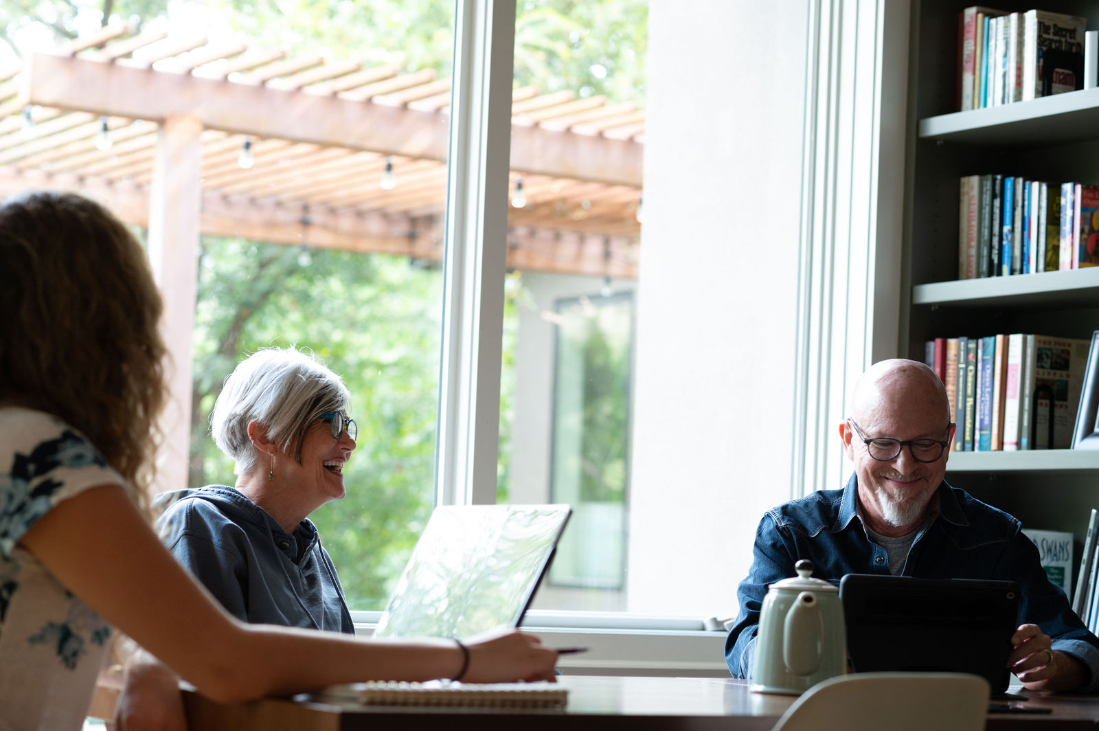 EHN Therapist in Austin, TX 1 Coworkers laughing together around a table near a sunny window