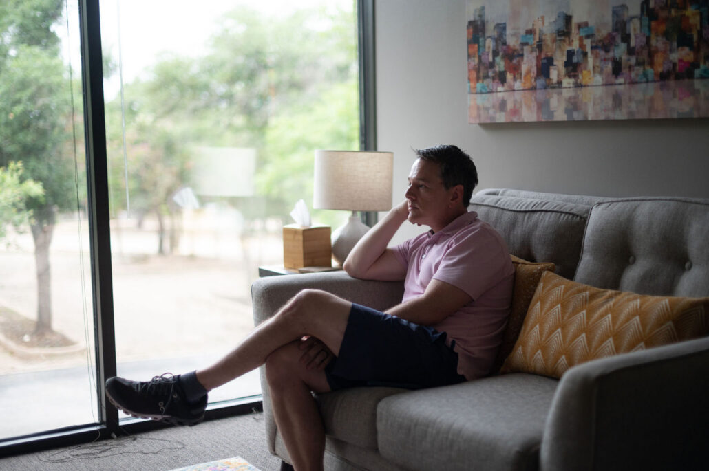 Virtual or In-Person Therapy? Choosing the Approach That Is Right for You 1 Man talking with his therapist by a sunny office window during an in-person session in Austin