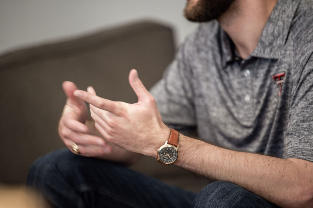 Man talking with his hands, a wristwatch on his wrist, for a post on the best wearable for ADHD