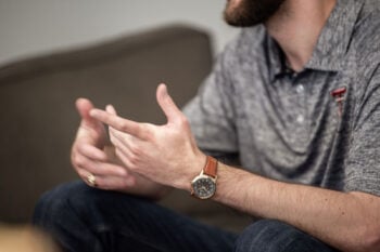 Man talking with his hands, a wristwatch on his wrist, for a post on the best wearable for ADHD